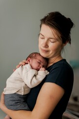 A newborn baby with a cleft lip sleeping peacefully on mothers hand, held gently by a parent.