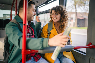 young caucasian couple talk and enjoy while riding a bus in the city