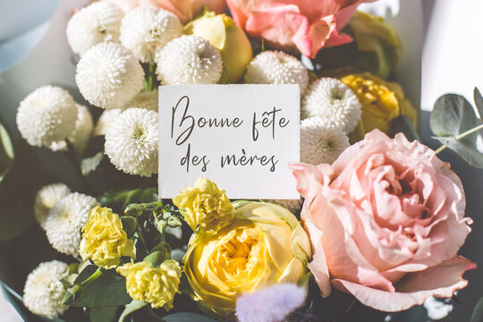 Elegant bouquet of pink roses, yellow carnations and white chrysanthemums with a handwritten note in French saying bonne f te des m res - happy mothers day, concept of celebration - Powered by Adobe