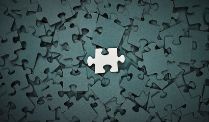 Single white puzzle piece stands out among dark pieces, symbolizing uniqueness, isolation, and...