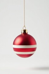 Striped Christmas ornament suspended in front of a white background, minimalist, ornament, red