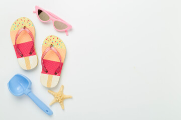 Children's flip flops and beach toys on color background,,top view