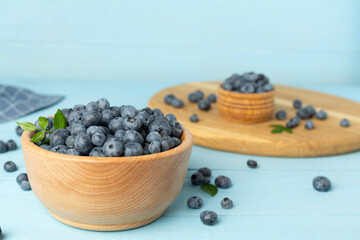 Bowl with fresh bright blueberries on wooden table