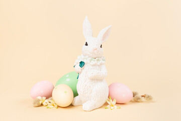 Easter bunny with painted eggs on color background