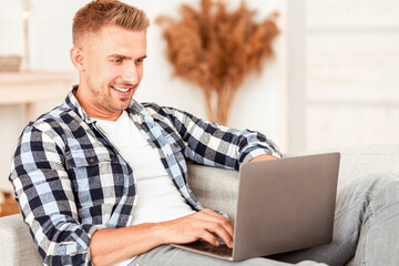 Freelance And Remote Work Concept. Portrait of positive man in checkered shirt chatting online...