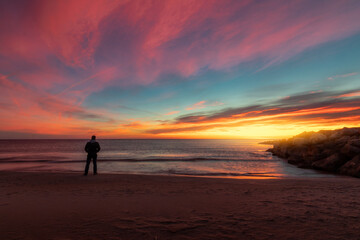 dramatic coastal landscape with colorful dramatic sky with person