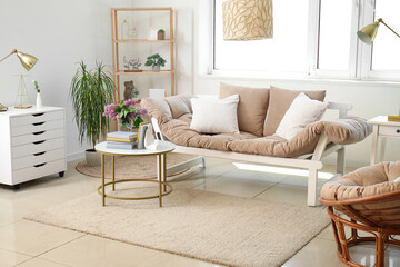 Interior of living room with sofa, armchair and stylish holder for books on coffee table