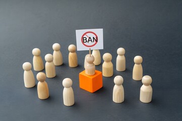 Obraz premium The Ban and the Collective: A symbolic depiction of opposition and restriction, featuring a central figure holding a 'ban' sign amidst a group of wooden figures, evoking themes of protest.