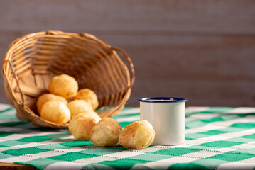 Brazilian cheese bread, delicious Brazilian cheese bread and accessories on a rustic table with a green and white checkered tablecloth, selective focus.