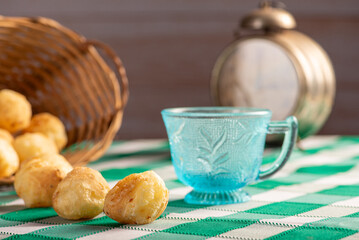 Brazilian cheese bread, delicious Brazilian cheese bread and accessories on a rustic table with a green and white checkered tablecloth, selective focus.