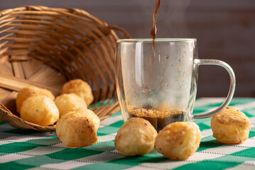 Brazilian cheese bread with coffee, delicious Brazilian cheese bread with a cup of coffee and accessories on a rustic table with a green and white checkered tablecloth, selective focus.