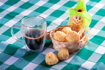 Brazilian cheese bread with coffee, delicious Brazilian cheese bread with a cup of coffee and accessories on a rustic table with a green and white checkered tablecloth, selective focus.