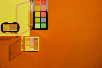 Beautiful palettes of eyeshadows on colorful background