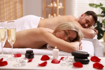Couple lying on massage tables in spa salon, selective focus