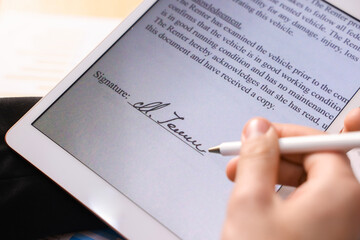 Electronic signature. Man using stylus and tablet at table, closeup