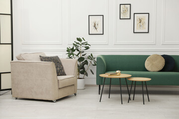 Stylish living room interior. Comfortable sofa, armchair and nesting tables indoors