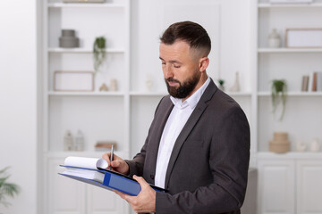 Real estate appraisal. Inspector with clipboard conducting property valuation indoors