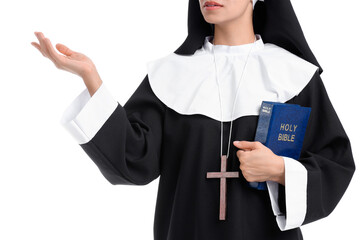 Young nun with Bible showing something on white background