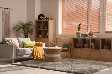 Interior of beautiful living room with sofa, coffee table, shelving units and houseplants