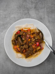 Hearty beef stew nestled alongside spongy injera, accompanied by bright vegetable medley highlighting ethiopian culinary traditions background wallpaper copy space
