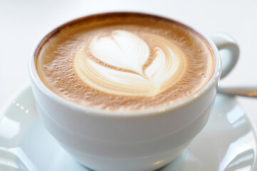 White Ceramic Cup of Cappuccino with Latte Art on Clean Surface