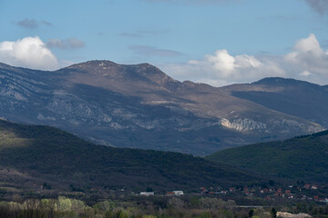 View of the mountain village from the air. A mountain village in Serbia. Behind the house they see mountains and a cloudy sky.
