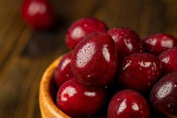 cherry berries in drops of water, wet red cherry fruits on the kitchen table