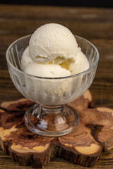 balls of fresh white ice cream in a glass, sweet refreshing ice cream on the table, side view