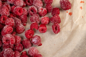 raspberries for long-term storage, frozen red raspberries during their melting for dessert in winter close up