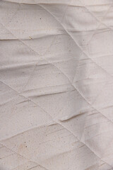 part of the fabric from which the mattress is sewn after prolonged use, closeup
