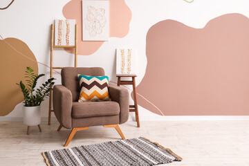 Armchair with cushion and pictures on wall in living room
