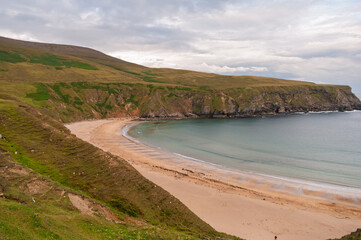 A beach with a cliff in the background