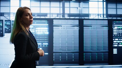 Fototapeta premium Engineer inspecting server room hardware, walking between supercomputers. IT professional supervising data center workplace, checking equipment, monitoring performance, camera B