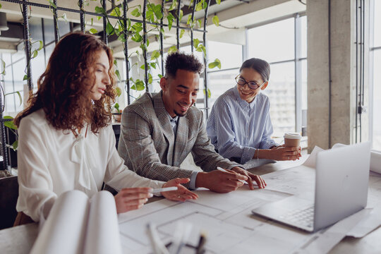 Three skilled professionals actively engaging in a collaborative and productive discussion in a bright office setting