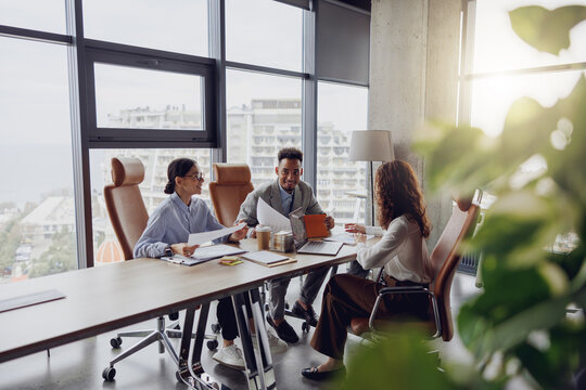 A professional team is engaged in an indepth discussion about strategies in a bright, modern conference room