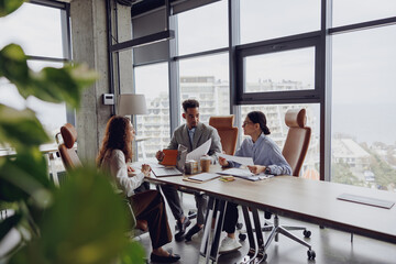 A diverse and skilled group of professionals are collaborating effectively in a stylish conference room setting