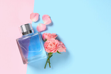 Bottle of perfume with beautiful pink roses and petals on colorful background