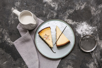 Plate with pieces of sweet vanilla cheesecake and jug of milk on black background