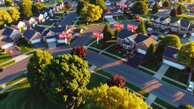 Aerial view of suburban neighborhood with sold signs indicating housing market activity