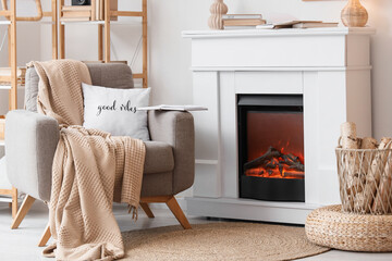 Interior of living room with fireplace, armchair and books