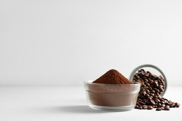 Bowl of coffee powder with beans on white background