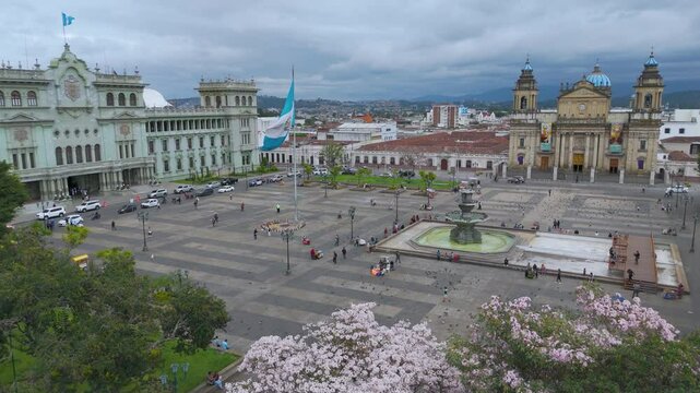 Panoramic view of the Plaza de la Constitucion in Guatemala City. The national flag flies proudly in the middle of the Metropolitan Cathedral and the Palace of Culture.