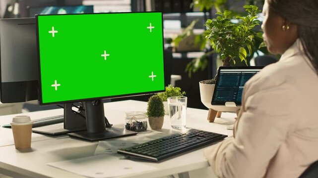 Office clerk working on green screen mockup PC to hit key performance targets for revenue and profitability. Employee at chroma key computer desk doing research analysis, camera A
