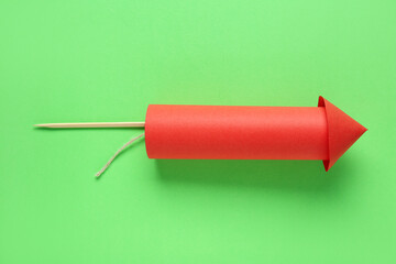 Red firework rocket on green background