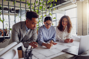 A diverse and talented team working collaboratively on innovative architectural plans within a...