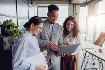 In a modern office space, team members are collaborating through an engaging discussion while using...