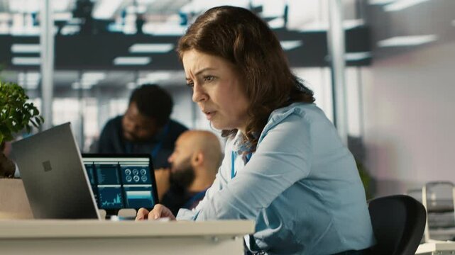 Upset employee in office dejected by bad news after reading negative email from business partner. Dejected worker frowning after failed client acquisition attempt, camera A