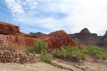 Stone wall with red cliffs behind it at Big Bend Ranch State Park in Texas