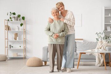 Obraz premium Mature woman hugging her mother at home
