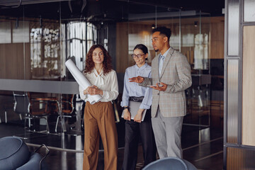 A diverse team of professionals is actively discussing their plans in a modern, innovative office setting